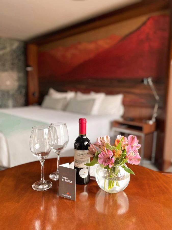 호텔 쿰브레스 라스타리아 산티아고 외부 사진 A bottle of wine and two wine glasses
